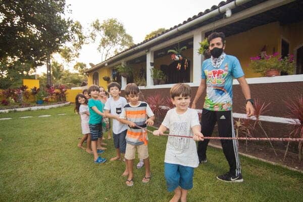 Niños en actividad de zancos en Galaxy Circus con instructor en jardín.