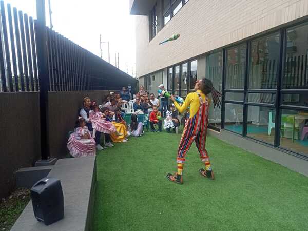 Payaso realizando malabares para niños en evento al aire libre en Galaxy Circus.