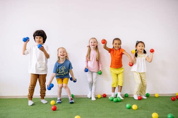 Niños jugando con pesas en actividad infantil en Galaxy Circus.